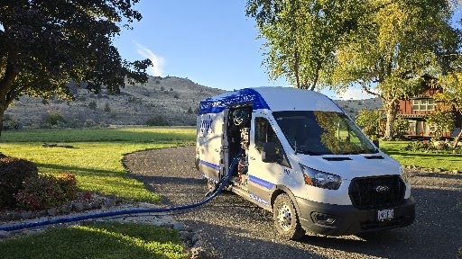 Summit facility services van with hose extended across a driveway