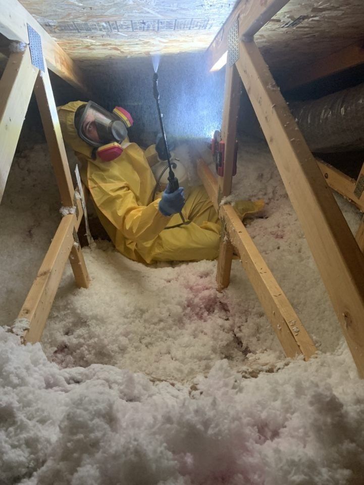 Technician in protective suit working in an insulated crawl space