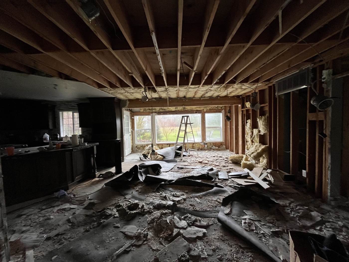 Fire-damaged room with exposed ceiling joists during interior cleanup