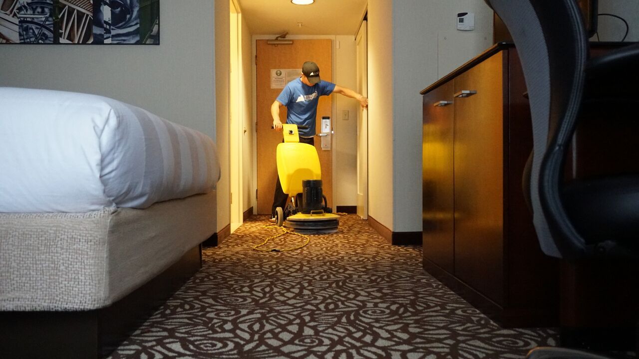 Summit technician running a carpet machine down a hotel hallway