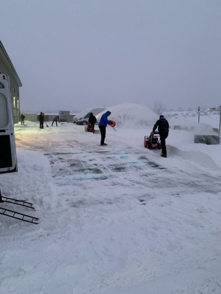 Summit technicians responding to ice damage outside a building