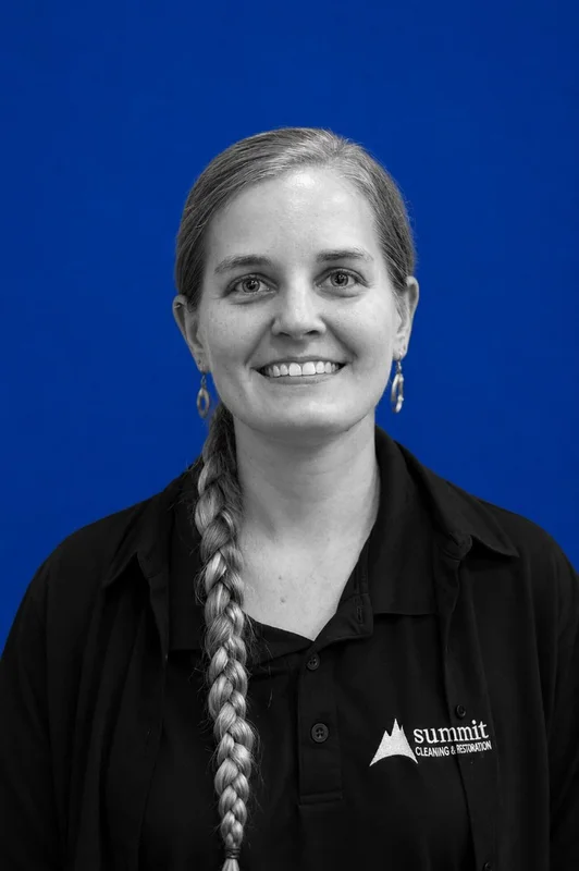 Annmarie Earl, Shop & Safety Manager at Summit Cleaning & Restoration — black-and-white portrait in a Summit-branded polo on Summit blue