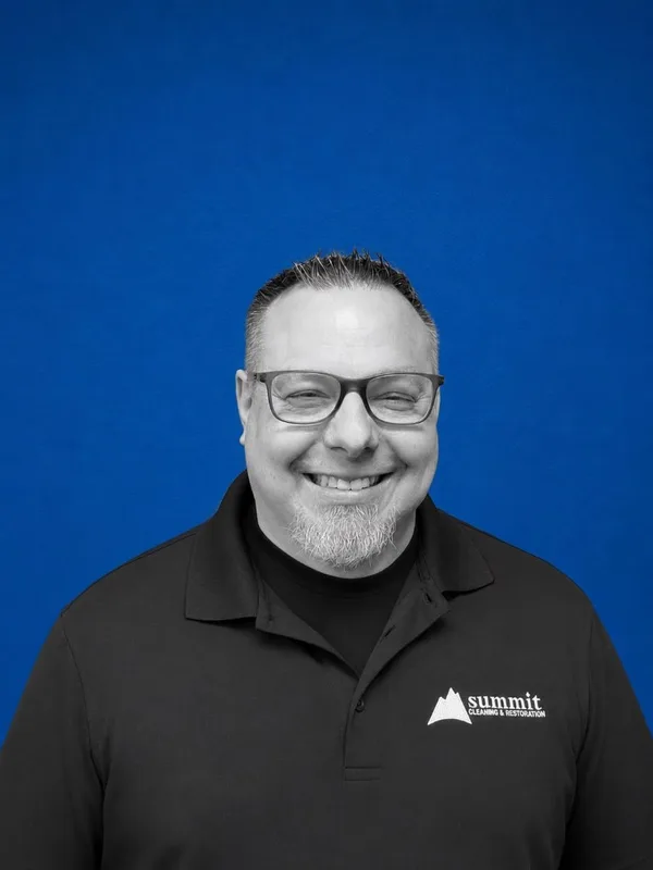 Daniel Moore, Director of Operations at Summit Cleaning & Restoration — B&W portrait on Summit cobalt