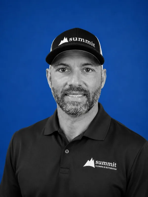 Jonathan Trendell, Director of Operations (Portland) at Summit Cleaning & Restoration — B&W portrait on Summit cobalt